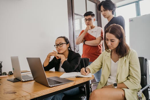 Diverse group of colleagues collaborating on a project in a modern office setting.